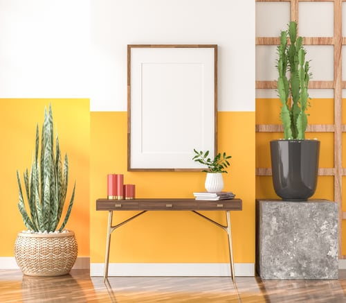 Two-tone painted entryway wall with a wood console table and framed art, finished by AR Interiors Decoration Inc